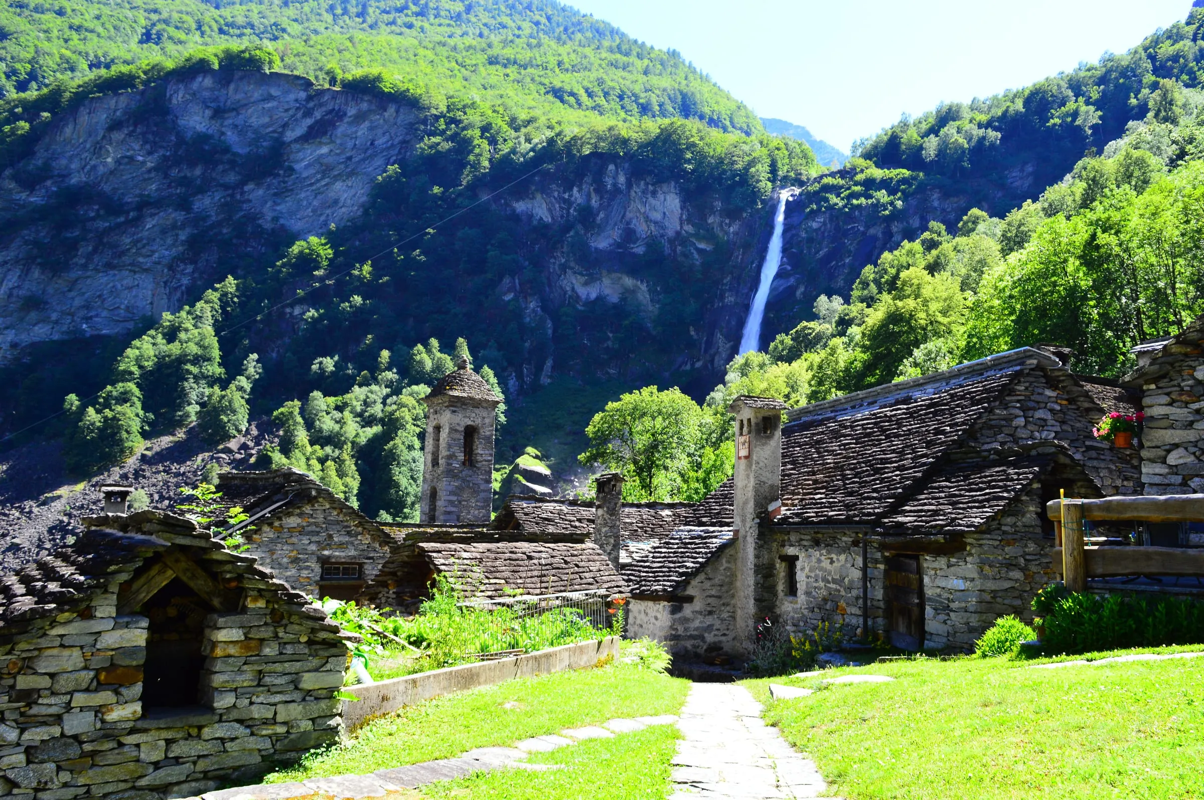 Steinhäuser von Foroglio im Val Bavona, dahinter stürzt der Wasserfall über die Felswand